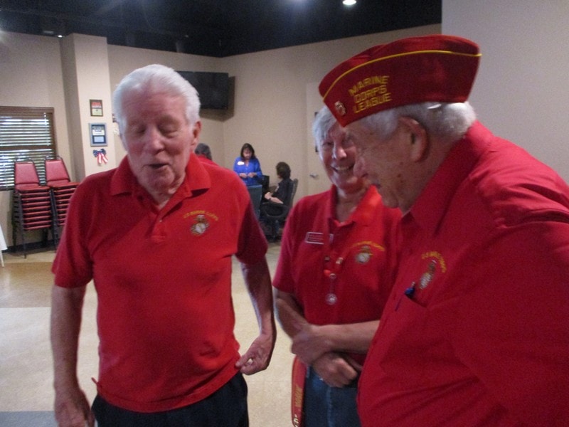 Elderly veterans in red uniforms talking