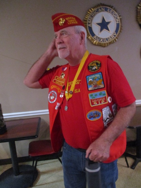 Veteran wearing red military vest with patches