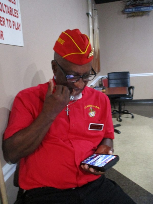 Veteran in red uniform using smartphone