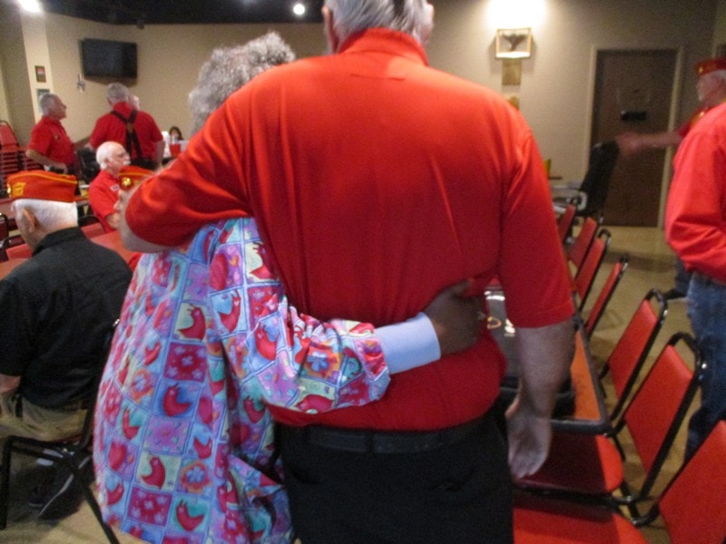Senior member comforting woman at community gathering