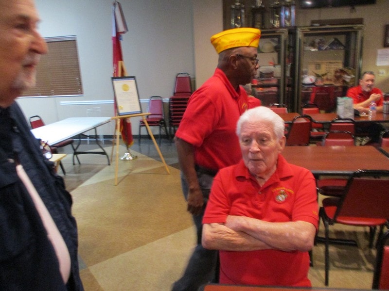Elderly veteran in red shirt at ceremony