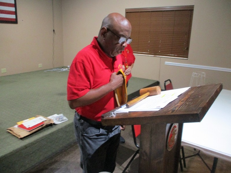 Member in red shirt speaking at podium