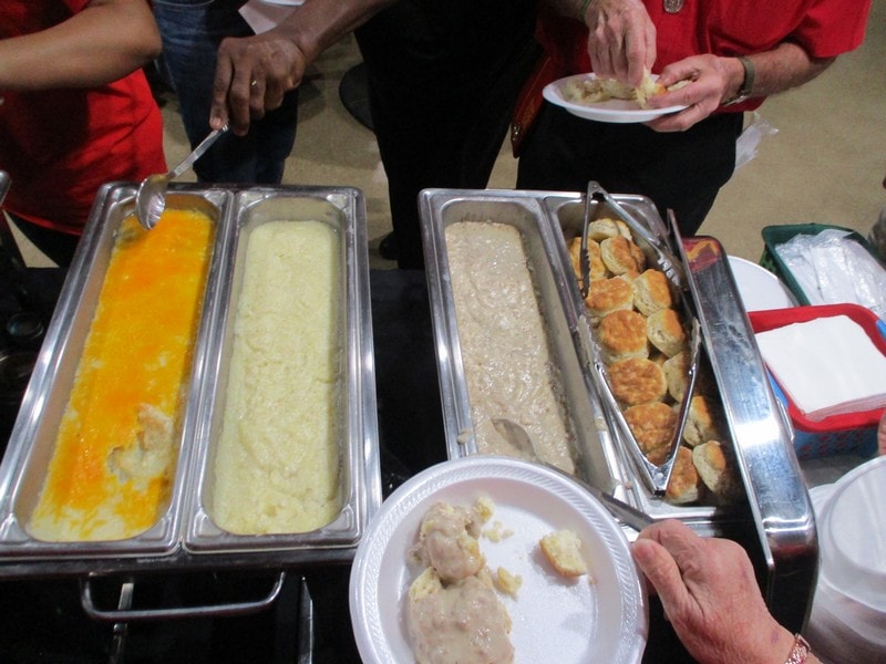 Members serving food from buffet trays