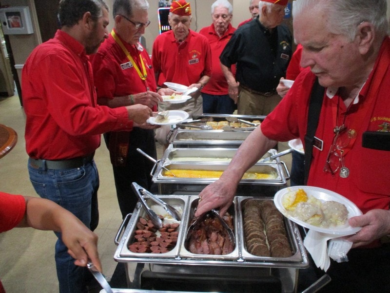 Group serving buffet meal together indoors