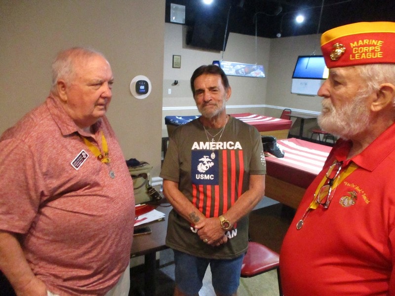 Three veterans conversing indoors patriotic setting