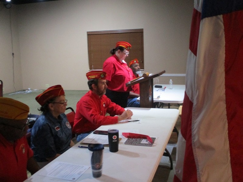 Members in red uniforms at meeting table