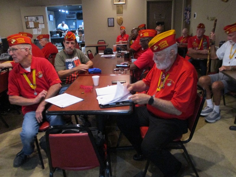 Veterans meeting in red uniforms indoors