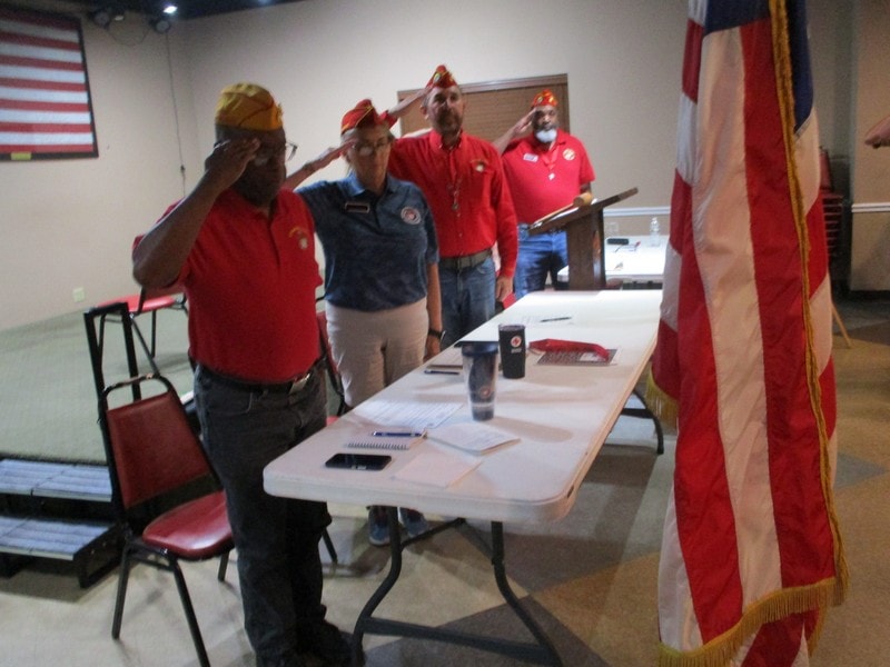 Veterans saluting at indoor ceremony event