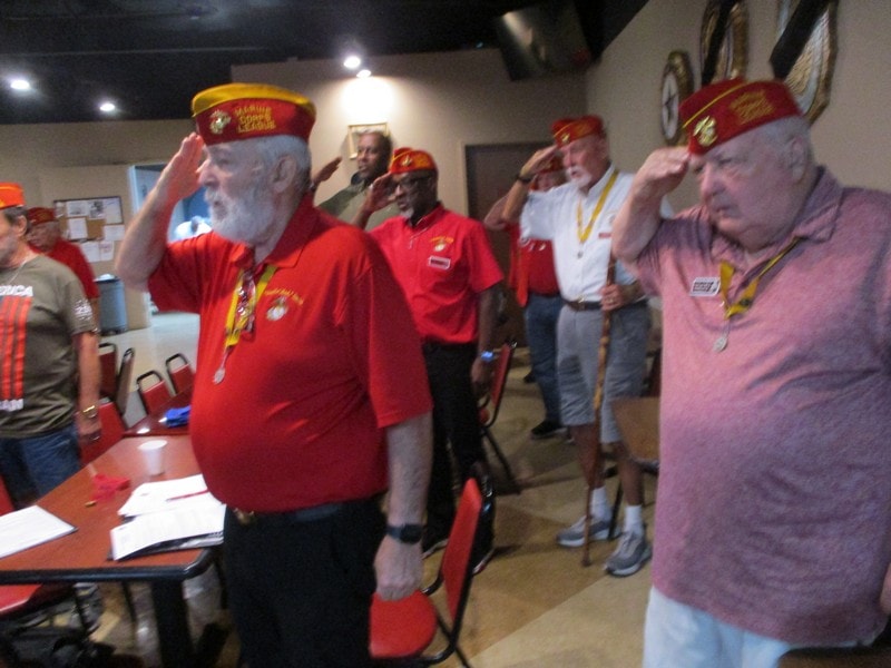 Veterans in red uniforms at indoor gathering